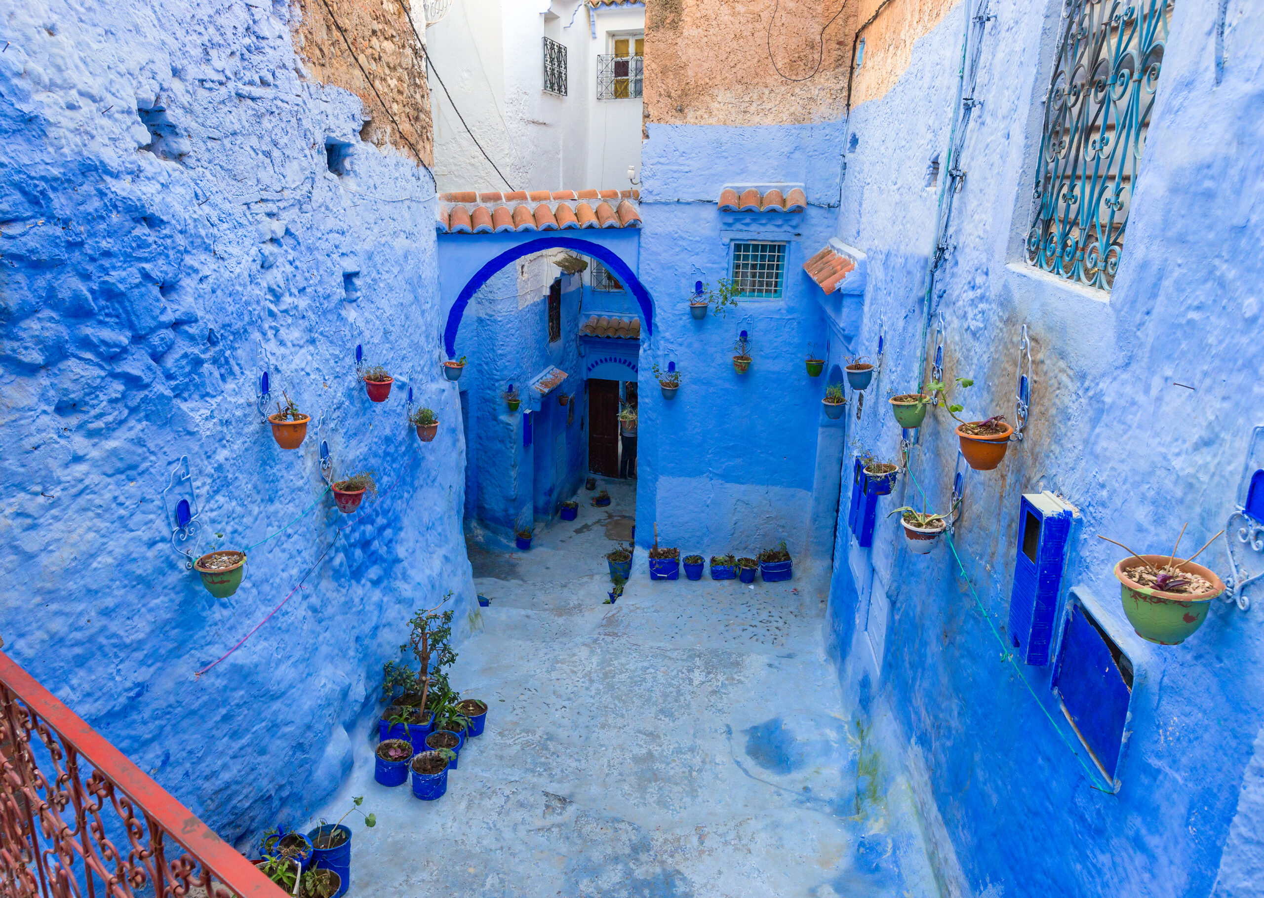 Traditional old blue street with color pots inside Medina of Chefchaouen, Morocco