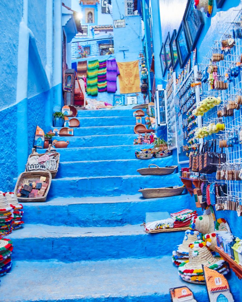 Many different Souvenirs and gifts in the streets of Chefchaouen. Paintings, carpets, clothing and handmade products on the streets of Morocco. Morocco, Chefchaouen 13 Dec 2017